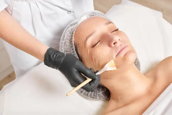 Cosmetologist Aplica Máscara Mel Cara Mulher Para Hidratar Pele Cara — Fotografia de Stock