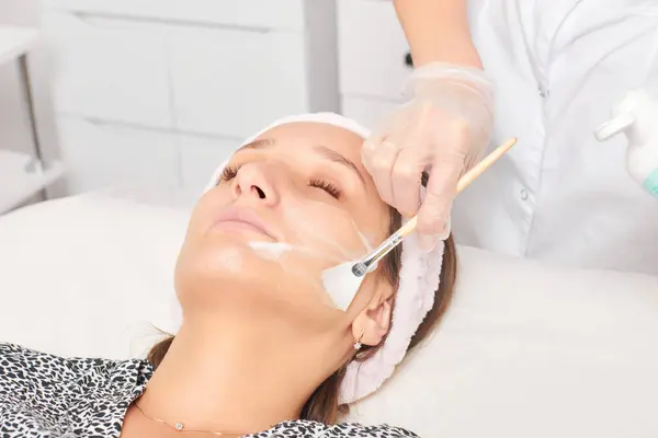 Kosmetikerin Anwendung Kosmetischer Creme Maske Auf Das Gesicht Der Frau — Stockfoto
