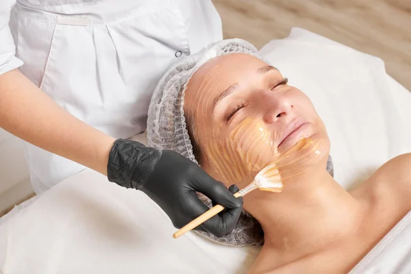 Beautician Applicerar Honungsmask Kvinnans Ansikte För Att Återfukta Ansiktet Hud — Stockfoto