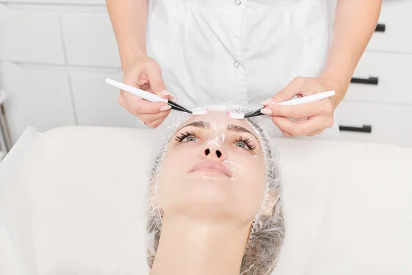 Kosmetolog Gnugga Grädde Med Borstar Kvinnan Ansikte Hud För Föryngring — Stockfoto