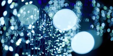 Noel tatili çelenklerinden gelen mavi ışıklar, bulanık arka plan, soyut açık hava ışıkları ve sigara. Parlak mavi Bokeh ışıkları, güzel, karanlık gece arka planında.