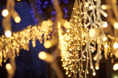 Sarı ışıklar Noel tatili çelenkleri, bulanık arka plan, soyut açık hava ışıkları ve sigara. Parlak sarı Bokeh ışıkları, güzel, karanlık gece arkaplanı.