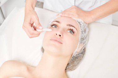 Güzellik uzmanı Gua Sha taşıyla yüz masajı yaparak güzellik salonundaki lenfatik drenaj, yaşlanmayı önleyen estetik ameliyatlar için cilde bakıyor. Gua Sha aracıyla yüz masajı