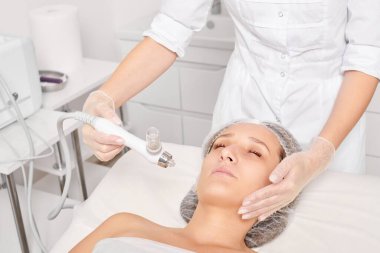 Güzellik uzmanı yüz gazı sıvı oksijen serumu epidermal kabuğunu gençleştirme için cilt bakımı, güzellik salonundaki yaşlanma karşıtı kozmetik prosedürü yapıyor. Kozmetik uzmanı yüz bakımı yapıyor