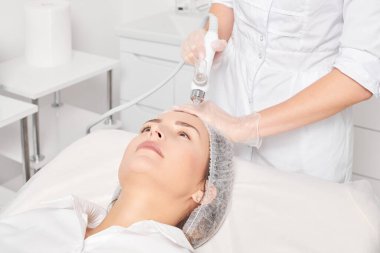 Güzellik uzmanı yüz gazı sıvı oksijen serumu epidermal kabuğunu gençleştirme için cilt bakımı, güzellik salonundaki yaşlanma karşıtı kozmetik prosedürü yapıyor. Kozmetik uzmanı yüz bakımı yapıyor