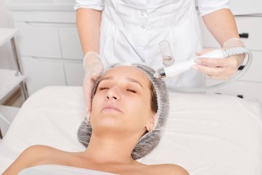 Güzellik uzmanı yüz gazı sıvı oksijen serumu epidermal kabuğunu gençleştirme için cilt bakımı, güzellik salonundaki yaşlanma karşıtı kozmetik prosedürü yapıyor. Kozmetik uzmanı yüz bakımı yapıyor