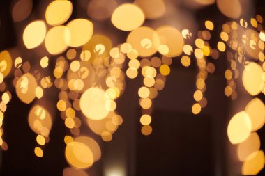 Sarı ışıklar Noel tatili çelenkleri, bulanık arka plan, soyut açık hava ışıkları ve sigara. Parlak sarı Bokeh ışıkları, güzel, karanlık gece arkaplanı.