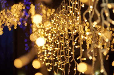 Sarı ışıklar Noel tatili çelenkleri, bulanık arka plan, soyut açık hava ışıkları ve sigara. Parlak sarı Bokeh ışıkları, güzel, karanlık gece arkaplanı.