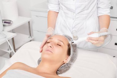 Kozmetik uzmanı yüz gazı sıvısı oksijen serumu epidermal kabuğunu gençleştirme için cilt bakımı, güzellik salonundaki yaşlanma karşıtı kozmetik prosedürü yapıyor. Güzellik uzmanı yüz bakımı yapıyor