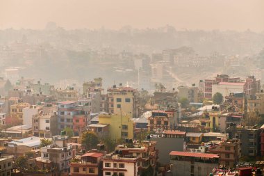 Nepal 'in Katmandu başkentinin dağdan şehir sisi boyunca manzarası alçak binalar, şehir manzarası dağ havasında ruhani bir atmosfer yaratıyor, Kathmandu hava kirliliği