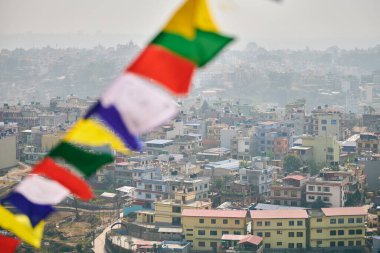 Katmandu manzarası, renkli dua bayrakları, tepe manzarası, ruhanilik ve kentselliğin ahenkli bir karışımı olan Katmandu manzarası.