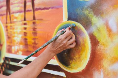 Kadın ressam el, resim çizer. Resim fırçasıyla sergi için, kadın el sanatları ressamının küçük dokunuşlarla muhteşem bir resim çizdiği yakın plan.