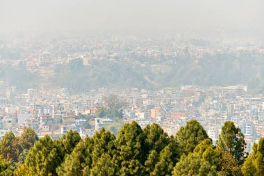 Nepal 'in Katmandu başkentinin dağdan şehir sisi boyunca manzarası alçak binalar, şehir manzarası dağ havasında ruhani bir atmosfer yaratıyor, Kathmandu hava kirliliği