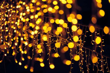 Yılbaşı için asılan çelenklerin yanıp sönen ışıkları gece sokak süslemeleri, mutlu Noeller ve parıldayan ışıklarla dolu mutlu yeni yıl havası.