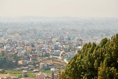 Nepal 'in Katmandu başkentinin dağdan şehir sisi boyunca manzarası alçak binalar, şehir manzarası dağ havasında ruhani bir atmosfer yaratıyor, Kathmandu hava kirliliği