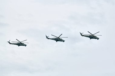 Mavi gökyüzünde füzelerle donanmış üç Rus askeri helikopteri, hedefleme sistemli savaş gemilerinin hava indirme görevi askeri harekat için bir hava manevrası, Rus havacılığı yapıyor.