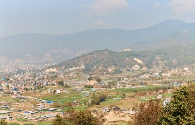 Nepal 'in Katmandu başkentinin dağdan şehir sisi boyunca manzarası alçak binalar, şehir manzarası dağ havasında ruhani bir atmosfer yaratıyor, Kathmandu hava kirliliği