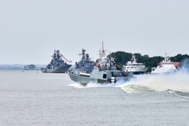 Rus deniz kuvvetleri boyunca yelken açan askeri savaş gemisi kıyı boyunca savaş gemilerini, kıyı boyunca denizcilik geleneğini, Rus deniz gücünü gösteren denizcilik gösterisini,