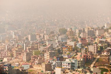 Nepal 'in Katmandu başkentinin dağdan şehir sisi boyunca manzarası alçak binalar, şehir manzarası dağ havasında ruhani bir atmosfer yaratıyor, Kathmandu hava kirliliği