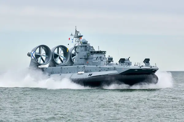 stock image Hovercraft warship armed with armament sails into sea toward military target to attack and destroy enemy, military hovercraft ship performing strategic maneuver, Russian sea power deployment