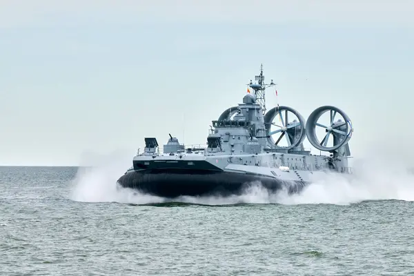 stock image Hovercraft warship armed with armament sails into sea toward military target to attack and destroy enemy, military hovercraft ship performing strategic maneuver, Russian sea power deployment