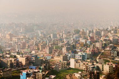 Nepal 'in Katmandu başkentinin dağdan şehir sisi boyunca manzarası alçak binalar, şehir manzarası dağ havasında ruhani bir atmosfer yaratıyor, Kathmandu hava kirliliği