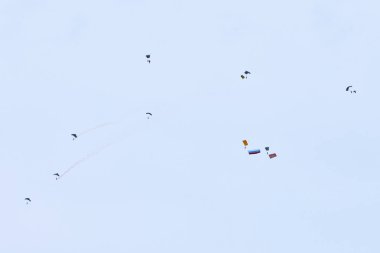 Airborne forces paratroopers soaring holding Flag of Russia and flags of military units, military exercise for celebration of Airborne Forces Day with formation landing, army airborne division descend clipart