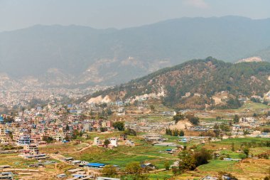 Nepal 'in Katmandu başkentinin dağdan şehir sisi boyunca manzarası alçak binalar, şehir manzarası dağ havasında ruhani bir atmosfer yaratıyor, Kathmandu hava kirliliği