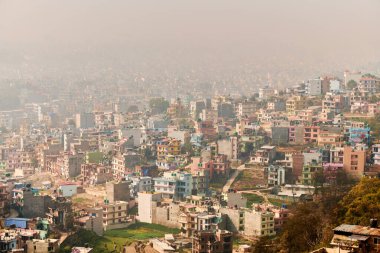 Nepal 'in Katmandu başkentinin dağdan şehir sisi boyunca manzarası alçak binalar, şehir manzarası dağ havasında ruhani bir atmosfer yaratıyor, Kathmandu hava kirliliği