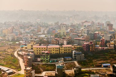 Nepal 'in Katmandu başkentinin dağdan şehir sisi boyunca manzarası alçak binalar, şehir manzarası dağ havasında ruhani bir atmosfer yaratıyor, Kathmandu hava kirliliği