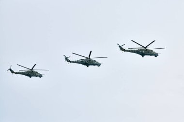 Mavi gökyüzünde füzelerle donanmış üç Rus askeri helikopteri, hedefleme sistemli savaş gemilerinin hava indirme görevi askeri harekat için bir hava manevrası, Rus havacılığı yapıyor.