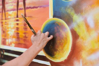 Kadın ressam el, resim çizer. Resim fırçasıyla sergi için, kadın el sanatları ressamının küçük dokunuşlarla muhteşem bir resim çizdiği yakın plan.