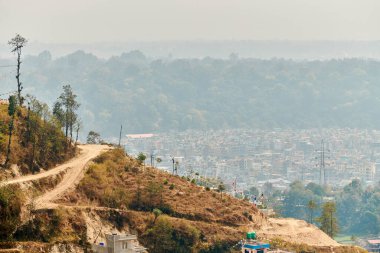 Nepal 'in Katmandu başkentinin dağdan şehir sisi boyunca manzarası alçak binalar, şehir manzarası dağ havasında ruhani bir atmosfer yaratıyor, Kathmandu hava kirliliği