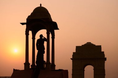 Silhouette of Subhas Chandra Bose statue under canopy behind India Gate war memorial in glorious sunset, monolithic Netaji statue made of black granite in New Delhi immortalizes Indian freedom fighter clipart