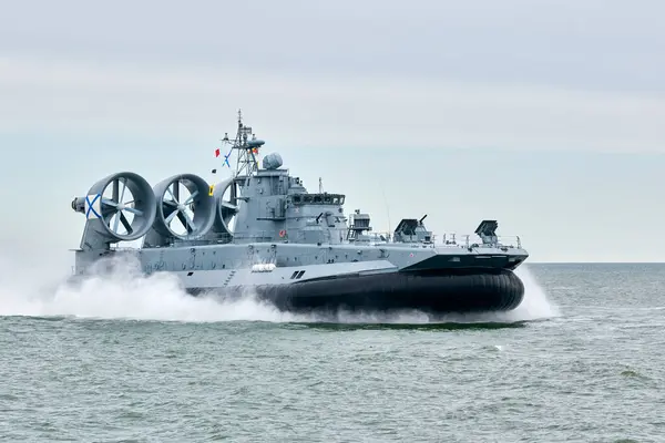 Stock image Hovercraft warship armed with armament sails into sea toward military target to attack and destroy enemy, military hovercraft ship performing strategic maneuver, Russian sea power deployment