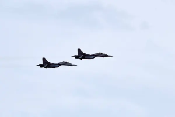 stock image Two Russian military fighter planes armed with missiles flies in blue sky, airborne mission of fighters with targeting system performs an aerial maneuvers for military operation, russian aviation