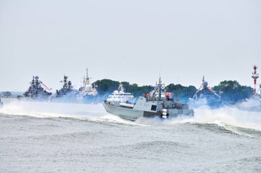 Rus deniz kuvvetleri boyunca yelken açan askeri savaş gemisi kıyı boyunca savaş gemilerini, kıyı boyunca denizcilik geleneğini, Rus deniz gücünü gösteren denizcilik gösterisini,