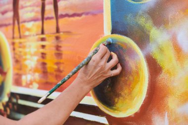 Kadın ressam el, resim çizer. Resim fırçasıyla sergi için, kadın el sanatları ressamının küçük dokunuşlarla muhteşem bir resim çizdiği yakın plan.