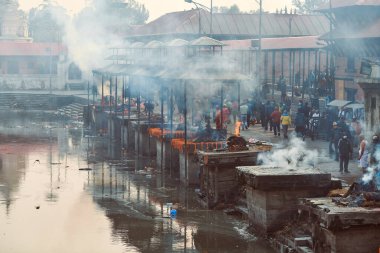Katmandu, Nepal - 01.02.2023 - Pashupatinath Tapınağı kompleksinde yas yakma töreni, Pandra Shivalaya 'nın yakıldığı yerden manzara, yaşam ve ölümün döngüsel doğasını sembolize ediyor.
