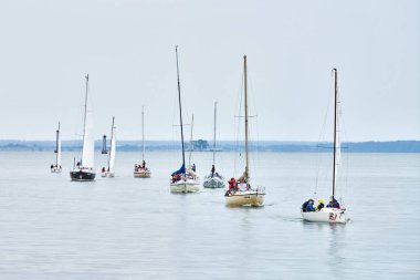Baltiysk, Rusya - 31.07.2022 - sahil boyundaki yatların geçit töreni, kıyı boyunca seyreden çok sayıda motorlu yelkenli yelkenli, denizcilik zarafetini, deniz tutkunları için yelken açmanın sevincini simgeleyen