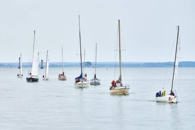 Baltiysk, Rusya - 31.07.2022 - sahil boyundaki yatların geçit töreni, kıyı boyunca seyreden çok sayıda motorlu yelkenli yelkenli, denizcilik zarafetini, deniz tutkunları için yelken açmanın sevincini simgeleyen