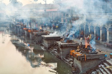 Katmandu, Nepal - 01.02.2023 - Pashupatinath Tapınağı kompleksinde yas yakma töreni, Pandra Shivalaya 'nın yakıldığı yerden manzara, yaşam ve ölümün döngüsel doğasını sembolize ediyor.