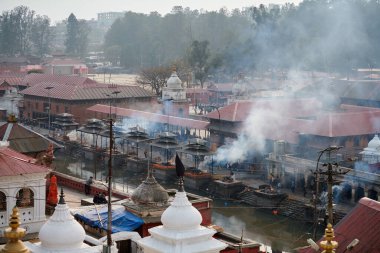 Katmandu, Nepal - 01.02.2023 - Pashupatinath Tapınağı kompleksinde yas yakma töreni, Pandra Shivalaya 'nın yakıldığı yerden manzara, yaşam ve ölümün döngüsel doğasını sembolize ediyor.