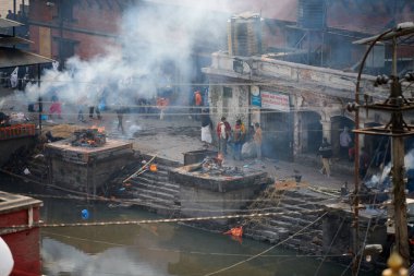 Katmandu, Nepal - 01.02.2023 - Pashupatinath Tapınağı kompleksinde yas yakma töreni, Pandra Shivalaya 'nın yakıldığı yerden manzara, yaşam ve ölümün döngüsel doğasını sembolize ediyor.