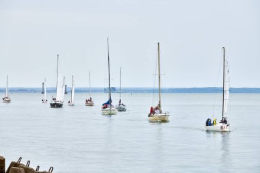 Baltiysk, Rusya - 31.07.2022 - sahil boyundaki yatların geçit töreni, kıyı boyunca seyreden çok sayıda motorlu yelkenli yelkenli, denizcilik zarafetini, deniz tutkunları için yelken açmanın sevincini simgeleyen