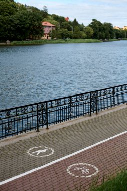 Lakeside yaya geçidi ve bisiklet sembolü ile farklı yürüme ve bisiklet şeritleri, dinlenme ve dinlenme için huzurlu bir ortam sunuyor