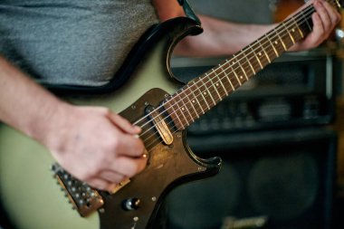 Elektronik bas gitar çalan müzisyenlerin ellerini kapatın, pratik performansı sırasında parmak yerleştirme ve frets üzerinde yoğunlaşın