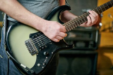 Elektronik bas gitar çalan müzisyenlerin ellerini kapatın, pratik performansı sırasında parmak yerleştirme ve frets üzerinde yoğunlaşın
