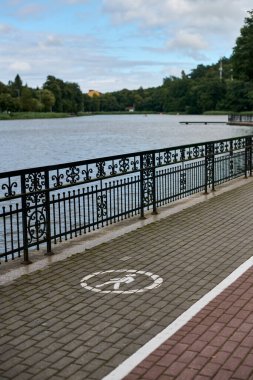 Lakeside yaya geçidi ve bisiklet sembolü ile farklı yürüme ve bisiklet şeritleri, dinlenme ve dinlenme için huzurlu bir ortam sunuyor