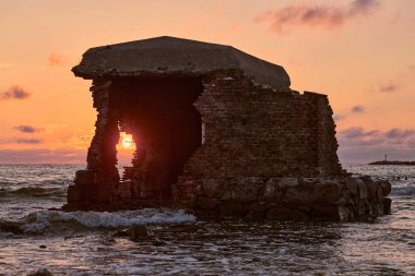 Günbatımı ışıltısıyla yıkanan antik taş kalıntıları okyanus dalgalarına karşı dayanıklı, Baltiysk 'teki terk edilmiş Batı Kalesi' nin kıyı sahasında nostalji ve dinginliği çağrıştırıyor.
